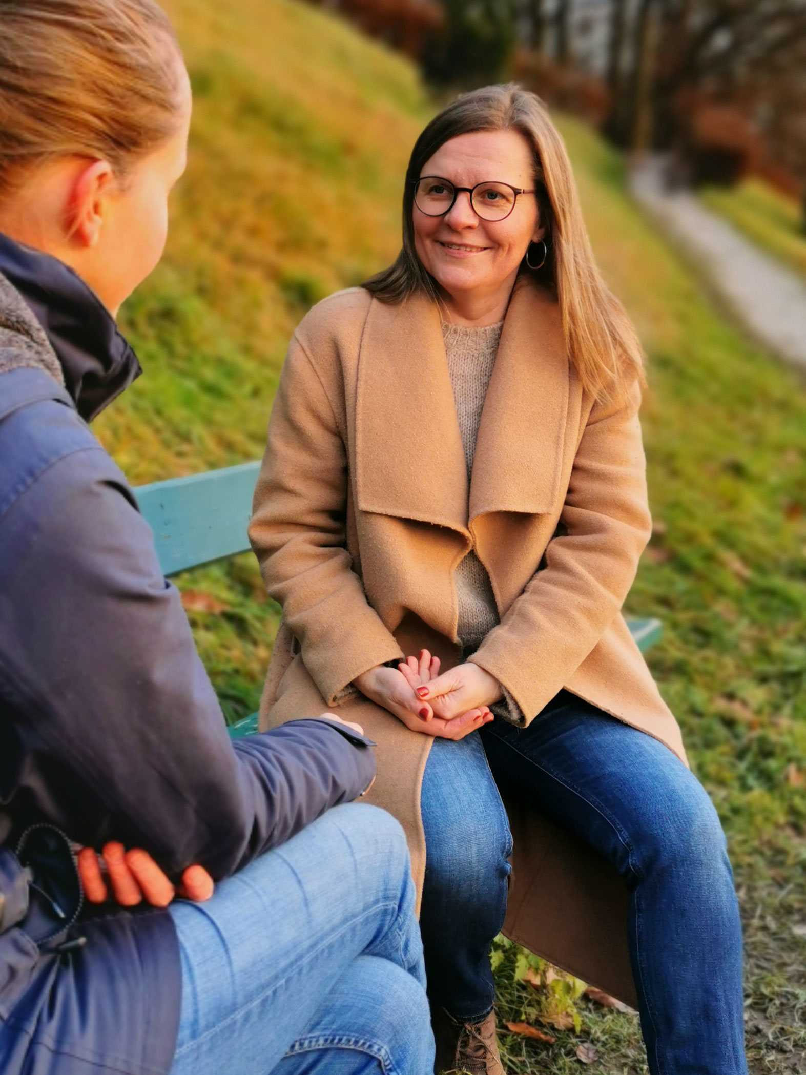 Daiva spricht mit einer Dame auf einer Parkbank